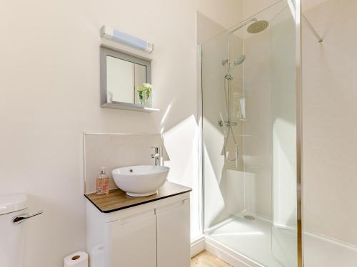 a white bathroom with a sink and a shower at Barn Owls Rest in Clyro