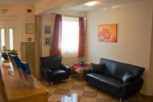 a living room with two chairs and a table at Korona Home in Sárvár