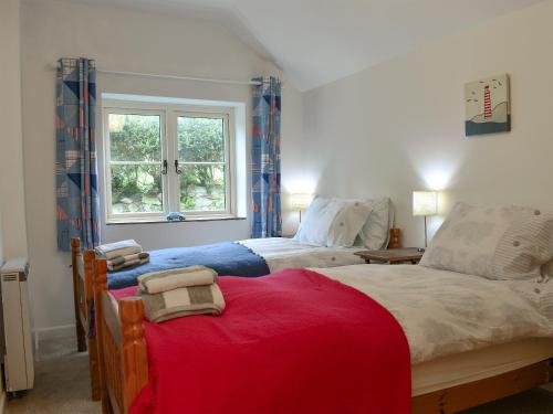 a bedroom with two beds and a window at Elm Cottage in Whitwell