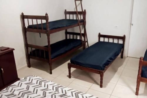 three wooden chairs with blue cushions in a room at Tropical House in Ilha Comprida