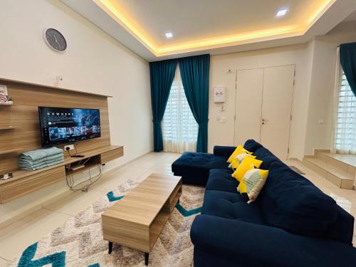 uma sala de estar com um sofá azul e uma televisão em Insyirah Homestay Melaka em Malaca