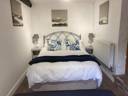 1 dormitorio con 1 cama con almohadas azules y blancas en The Old Tearoom-uk32945, en Great Salkeld