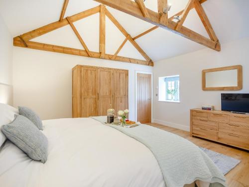 a bedroom with a white bed and a tv at The Stable - Uk35021 in Long Houghton
