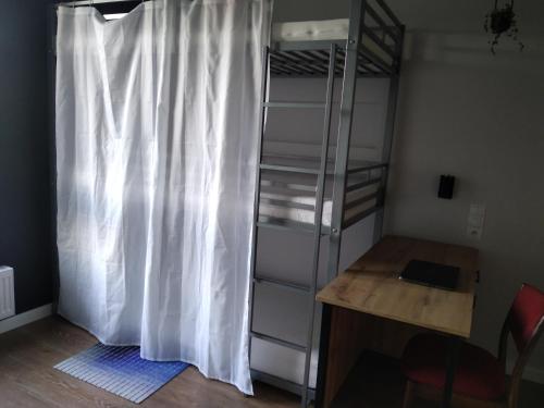 a bedroom with a bunk bed and a desk and a curtain at RADLIŃSKA FOLWARK in Kielce