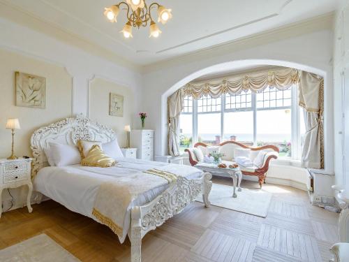 a bedroom with a white bed and a large window at South Cliff in Bessingby