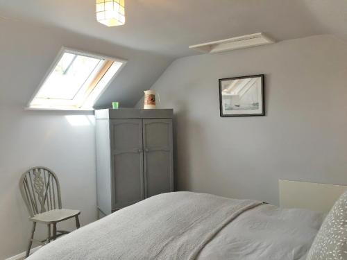 1 dormitorio con 1 cama, 1 silla y 1 ventana en Oak Cottage, en Clifton