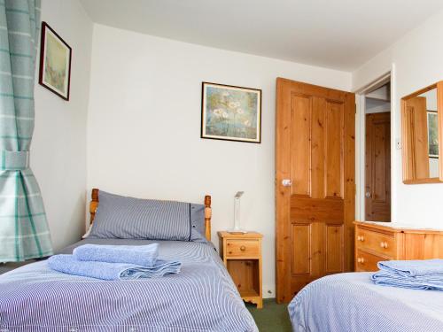 塞特爾的住宿－Ivy Cottage，一间卧室设有两张床和木门