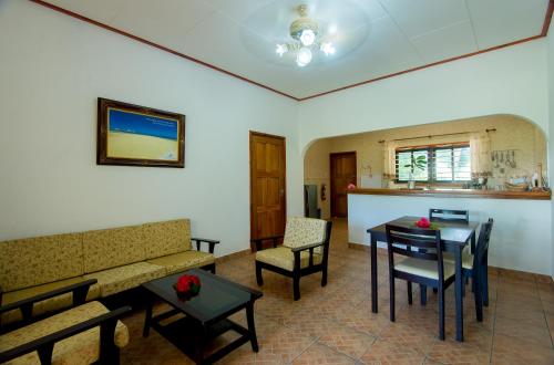 a living room with a couch and a table and chairs at Zerof Self Catering Apartments in La Digue