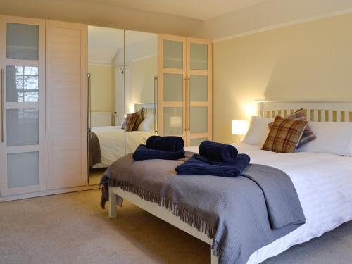 a bedroom with a large bed with two towels on it at Straton Cottage in Saint Cyrus