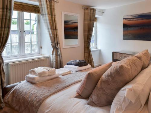 a bedroom with a bed with two towels on it at Anchor Cottage in Instow
