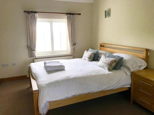 1 dormitorio con 1 cama con sábanas blancas y ventana en Brankley Cottage - E4712, en Dunstall