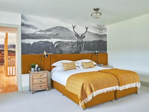 a bedroom with a bed with a deer mural on the wall at Midcraigs in Kilchenzie