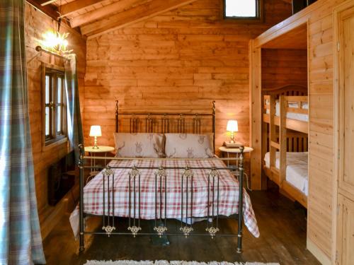 a bedroom with a bed and two bunk beds at The Sunset Cabin in Beccles