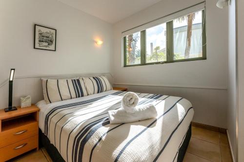 a bedroom with a bed with a towel on it at Onetangi Beach Apartments in Onetangi