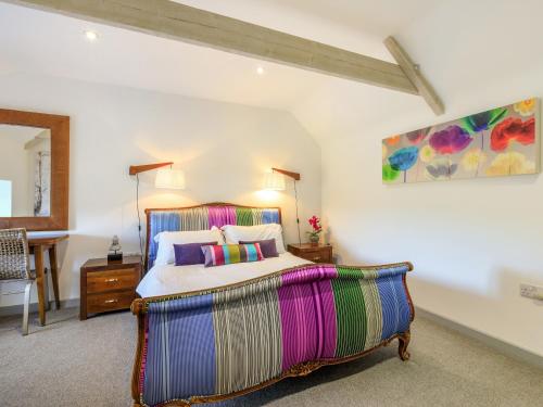 a bedroom with a large bed and a table at The Cow Shed in Buckland St Mary