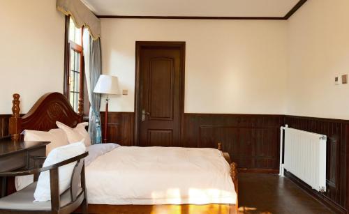 a bedroom with a bed and a desk and a table at Nordic Memory in Qingdao in Qingdao
