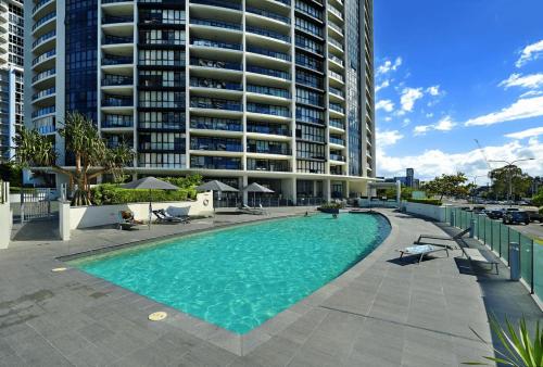 a swimming pool in front of a large building at Beautiful Ocean View High Floor 3 Bedroom Apartment at Sierra Grand in Gold Coast