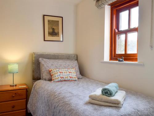 a bedroom with a bed with a pillow and a window at Mallards Nest in Skipton