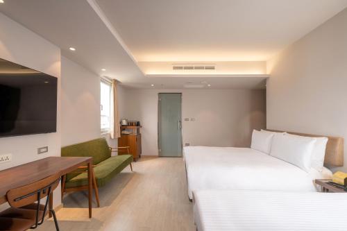a hotel room with a bed and a table and a couch at Inns Hotel in Kaohsiung
