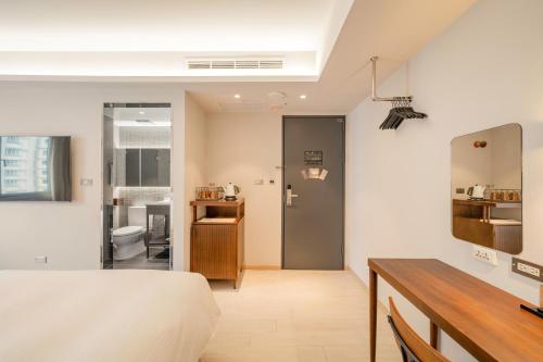 a bedroom with a bed and a bathroom at Inns Hotel in Kaohsiung