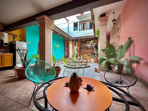un patio con tavolo, sedie e una casa di Hostal Central Oaxaca a Città di Oaxaca