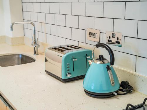 a blue tea kettle on a counter next to a toaster at Penthouse 47 Zinc in Newquay