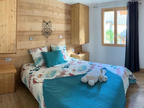 a teddy bear sitting on a bed in a bedroom at Chalet 8 pers 4* à Valloire - Centre, Terrasse, Proximité Télécabine et Commerces - FR-1-263-524 in Valloire