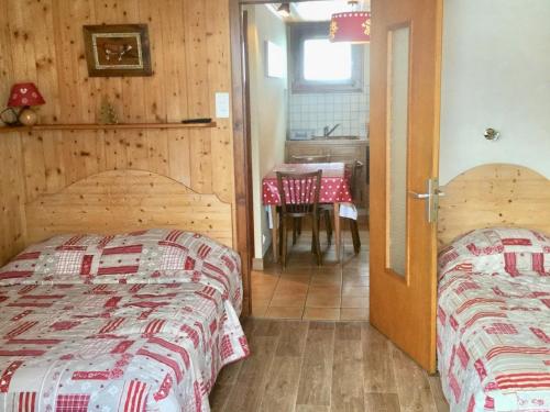 two beds in a room with a table and a dining room at Appartement Les Gets, 1 pièce, 3 personnes - FR-1-671-129 in Les Gets