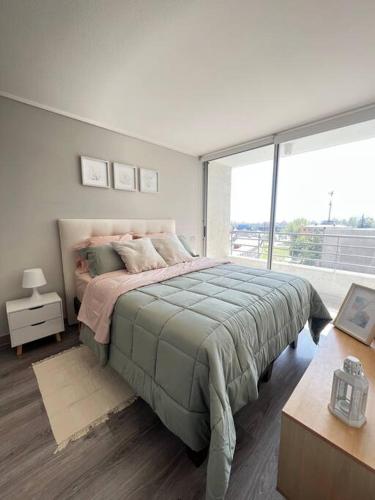 a bedroom with a large bed and a large window at Apartamento General Mackenna B&E in Santiago