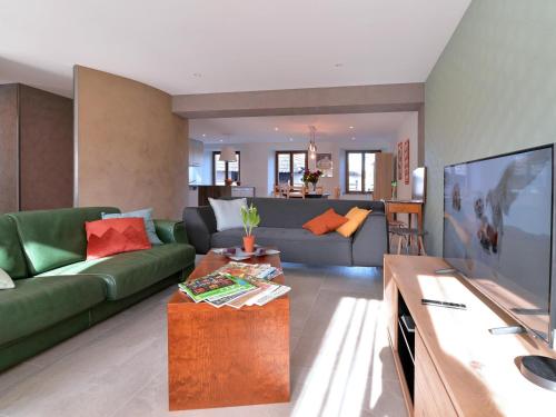 a living room with a couch and a television at Charmant appartement rénové pour 4 pers avec terrasse à Hunawihr - FR-1-744-14 in Hunawihr