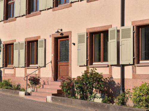 a building with green shuttered windows and a door at Charmant appartement rénové pour 4 pers avec terrasse à Hunawihr - FR-1-744-14 in Hunawihr