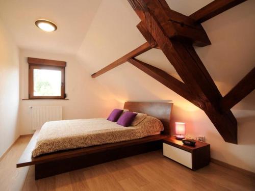 una camera con letto, finestra e travi in legno di Gîte Eguisheim, 3 pièces, 4 personnes - FR-1-744-15 a Eguisheim