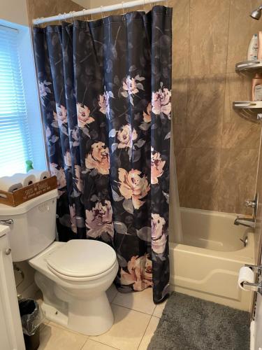 a bathroom with a toilet and a shower curtain at Downtown Private Room - Close to M&T, Orioles, Topgolf, Horseshoe Casino in Baltimore