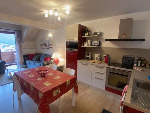 une cuisine et un salon avec une table et un canapé dans l'établissement Superbe duplex face aux pistes, sud, 8 pers, 3 ch, balcon, parking, proche commerces - FR-1-445-198, à Montgenèvre