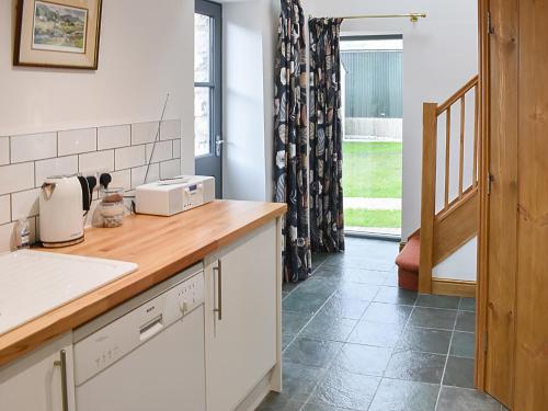 a kitchen with white cabinets and a counter top at Ower Yonder in Ingleton