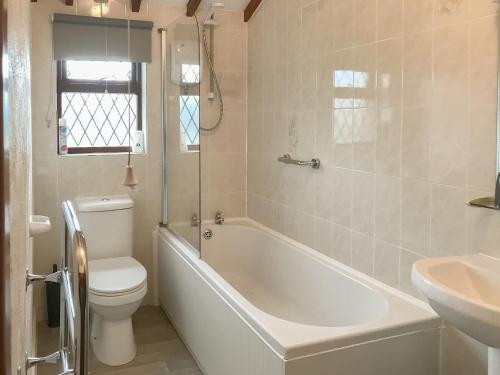 een badkamer met een bad, een toilet en een wastafel bij Golden Meadows - Uk12272 in Mevagissey