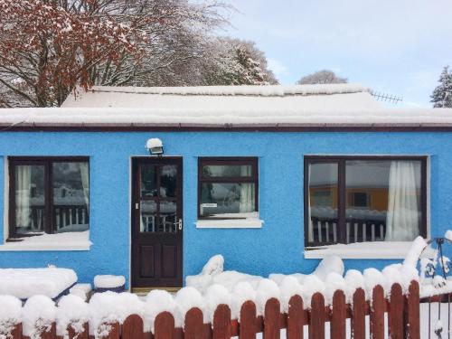 a blue house with snow on the roof at The Cairngorms - Uk7096 in Contin