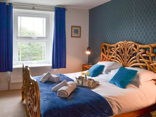1 dormitorio con 1 cama grande y paredes azules en Cranford House, en Woolfardisworthy
