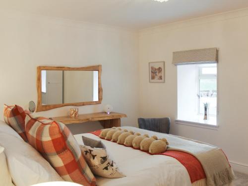 a living room with a couch and a mirror at Rhunahaorine Cottage in Gortinanane