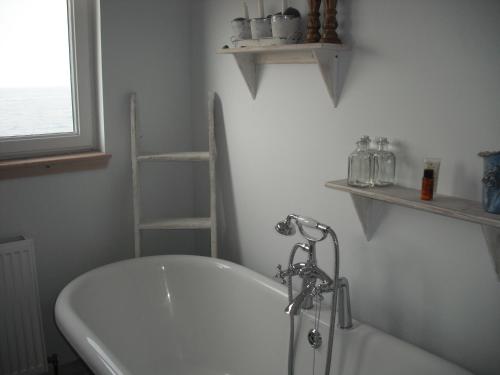 a white bath tub in a bathroom with a window at Gull Cottage in Lendalfoot
