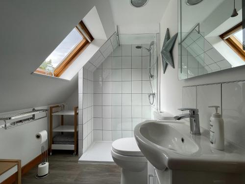 a bathroom with a sink and a toilet and a window at Lag Cottage in Dornie