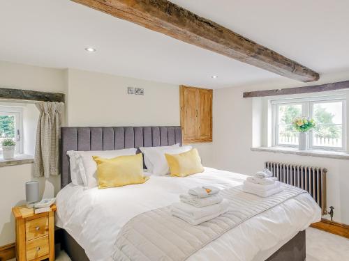 a bedroom with a large bed with towels on it at Alton Hall Cottage in Ashover