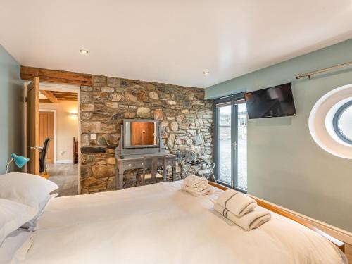 a bedroom with a large bed and a stone wall at Seascape in Holyhead