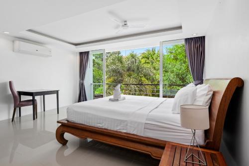 1 dormitorio con cama y ventana grande en 4 bedrooms & bathroom for up to 12 guests 7kms to Patong beach at The Fairways golf villas en Phuket