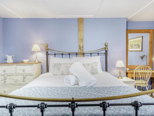 a bedroom with a bed with towels on it at Duck Island Cottage in Ringwood