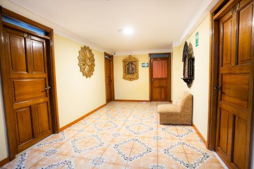 a hallway with doors and a chair and tiled floor at Santuario Machupicchu in Machu Picchu