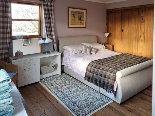 A bed or beds in a room at The Hen Hoose