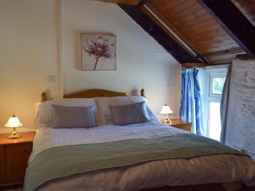 a bedroom with a large bed with two lamps at The Carthouse - Uk13184 in Cwm-Morgan