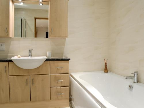 een badkamer met een bad, een wastafel en een bad tubermottermott bij Castle Howe in Rosthwaite
