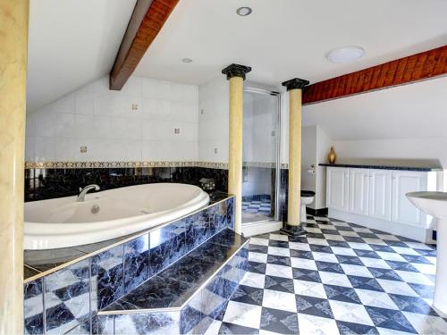 a bathroom with a tub and a checkered floor at Lane House in Threshfield
